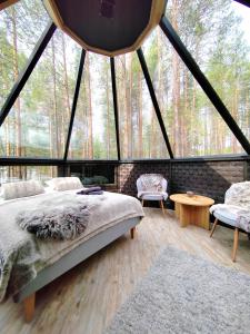 罗瓦涅米LakeLodge Kiehinen & Igloos的帐篷内的卧室,配有一张床和两把椅子