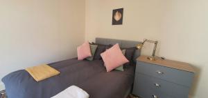 考文垂Coventry Spacious Rooms In City的一间卧室配有带枕头的床铺和梳妆台