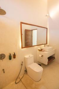 卢纳将军城SEACLUB Siargao的一间带卫生间、水槽和镜子的浴室