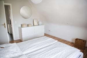 兰河畔马尔堡DG-Wohnung mit sonnigem Balkon的白色卧室配有床和镜子