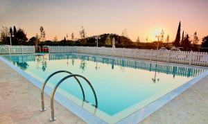 佩萨河谷塔瓦内莱ISA-Residence with swimming-pool in Barberino-Tavernelle, apartments with air conditioning and private outdoor area的一个带围栏的大型游泳池,享有日落美景