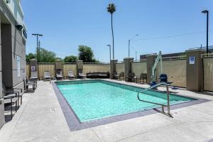 凤凰城菲尼克斯城机场北希尔顿花园旅馆的一座游泳池,位于一座带椅子的建筑中