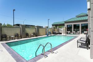 凤凰城菲尼克斯城机场北希尔顿花园旅馆的一座带椅子的大型游泳池和一座建筑