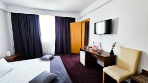 锡比乌伊甸酒店的酒店客房配有一张床、一张桌子和一把椅子。