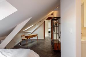 梅赫伦Uma's Urban Lounge的一间卧室配有一张床、一张书桌和一个楼梯
