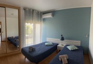 蒙蒂戈杜Beach House Carmen 2的蓝色的客房设有两张床和窗户。