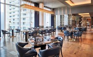 迪拜Waldorf Astoria Dubai International Financial Centre的餐厅设有桌椅和窗户。