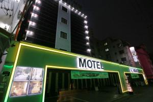 富川市Motel Lamant的一间商店,上面标有汽车旅馆在大楼前的标志