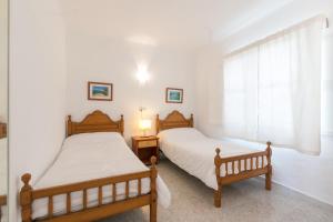 帕尔马海滩Villa los brezos的卧室设有两张单人床和窗户。