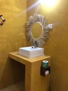 马特姆维Mohammed Bungalows and Restaurant的浴室设有镜子和白色水槽