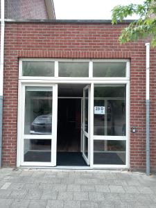 耶尔瑟克Yerseke Maarten & Hanh的砖砌建筑的敞开的门,里面装有汽车