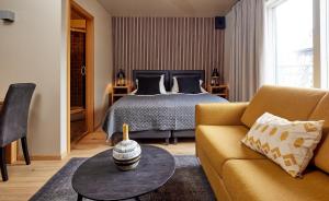 雷克雅未克芙蓉酒店的一间卧室配有一张床、一张沙发和一张桌子