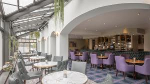 肯尼迪山新镇格兰维尔酒店及休闲俱乐部的一间设有紫色桌椅的餐厅和一间酒吧