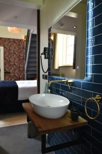 ReitsumKerkhotel Bij De Pastorie的一间带水槽和镜子的浴室以及一张床