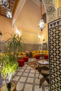 非斯Riad Diamant De Fes的大堂配有沙发、桌子和植物