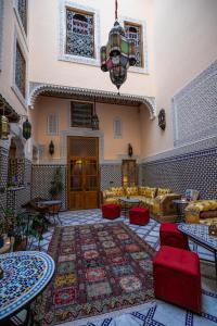 非斯Riad Diamant De Fes的客厅配有沙发、桌子和地毯