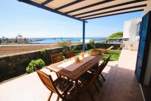 阿雷西费Casa Bahia de Naos con vistas al mar的海景庭院设有一张木桌和椅子。