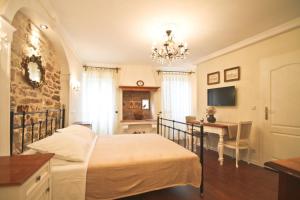 罗维尼卡萨巴戚尔瑞公寓的一间卧室配有一张床、一张书桌和一个吊灯。