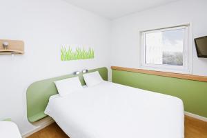 里瓦日卢森堡宜必思经济酒店的一间卧室设有一张床和一个窗口
