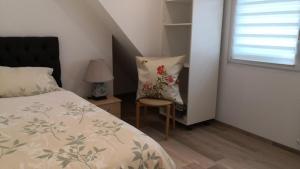里拉辛根-沃布林根FeWo Aachweg的卧室配有床、椅子和窗户。