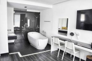清迈NANEE Phra Singh - Adults Only的浴室配有大浴缸、水槽和浴缸。