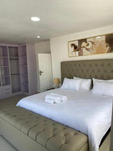 恩多拉Swiss Luxury Apartments的卧室配有带毛巾的大型白色床