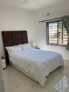 恩多拉Swiss Luxury Apartments的白色的卧室设有一张大床和一个窗户