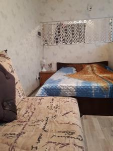 阿斯塔纳Zhenis street的一间卧室设有两张单人床和床头板