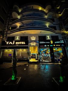 亚喀巴TAJ Hotel的夜间在建筑物前的商店