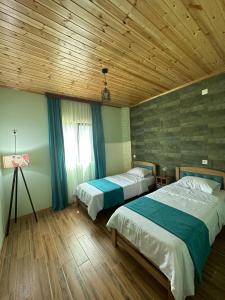 安布罗劳里WoodStar的一间卧室设有两张床和木制天花板