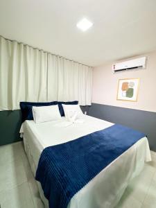 帕图斯Hotel Haki的一间卧室配有一张带蓝白色床单的大床
