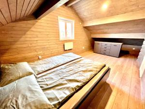 穆列什河畔圣乔治乌Vila Scandinavia的木墙客房内的一张大床