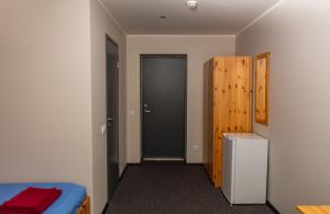 KuremaaKuremaa Külalistemaja的一间卧室配有一张床、一扇门和一台冰箱