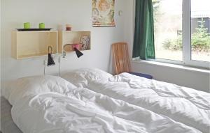 福旺Cozy Home In Frvang With Kitchen的卧室内的一张未铺好的床,设有窗户