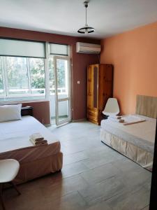 普列文HOTEL PLEVEN的配有橙色墙壁和窗户的客房内的两张床