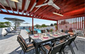 Gorgeous Home In Sedlarica With Heated Swimming Pool的庭院内一张带椅子和遮阳伞的餐桌