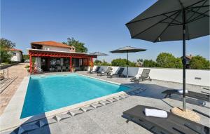 Amazing Home In Sedlarica With Heated Swimming Pool的一个带庭院家具和遮阳伞的游泳池