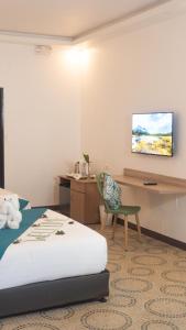 长滩岛Boracay Sea View Hotel的酒店客房配有一张床、一张桌子和一把椅子。