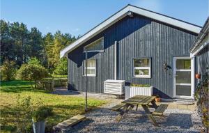 ØksenmølleStunning Home In Ebeltoft With Kitchen的蓝色房子前面设有野餐桌