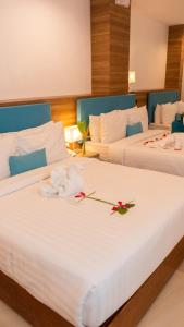 长滩岛Boracay Sea View Hotel的两张位于酒店客房的床,上面有鲜花