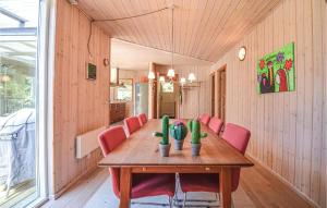 ØksenmølleNice Home In Ebeltoft With Kitchen的一间带木桌和红色椅子的用餐室