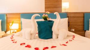 长滩岛Boracay Sea View Hotel的两个天鹅,用玫瑰制成,睡在床上