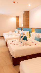 长滩岛Boracay Sea View Hotel的酒店客房设有三张床,上面有天鹅