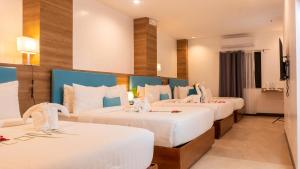 长滩岛Boracay Sea View Hotel的酒店客房,配有3张带白色床单的床