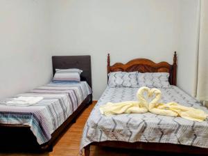 伊塔茹巴Básico e Aconchegante的一间卧室配有两张带毛巾的床