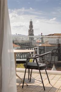波尔图Wine & Books Porto Hotel的享有大楼景致的阳台上的椅子