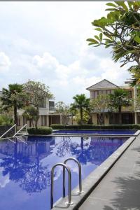 班图尔Omah Dixy Family Homestay by FH Stay的蓝色海水度假村的游泳池