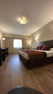 布兰卡港Land Plaza Hotel的酒店客房设有一张大床和一张书桌。