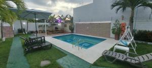 巴兰基亚Cabaña villa kary的一个带椅子和遮阳伞的游泳池
