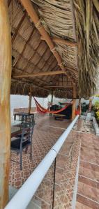 巴兰基亚Cabaña villa kary的茅草屋顶下带长凳和吊床的凉亭